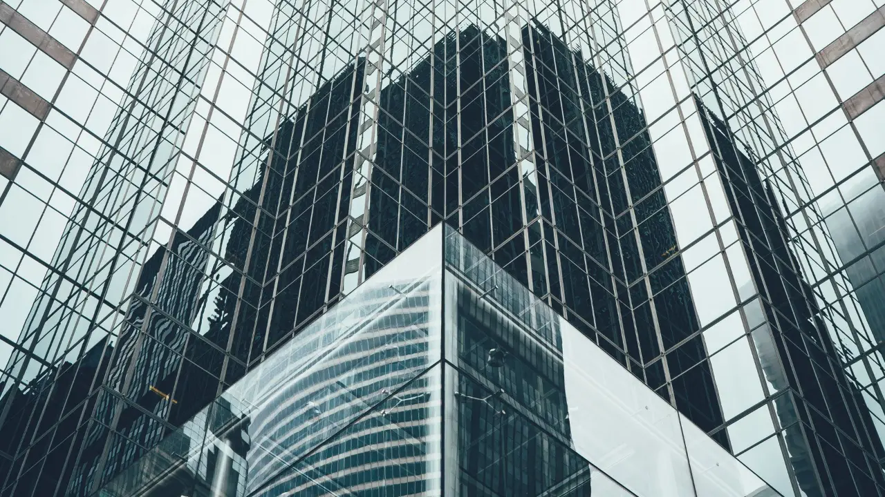 Le V de reflets à la base d'une tour de verre.
