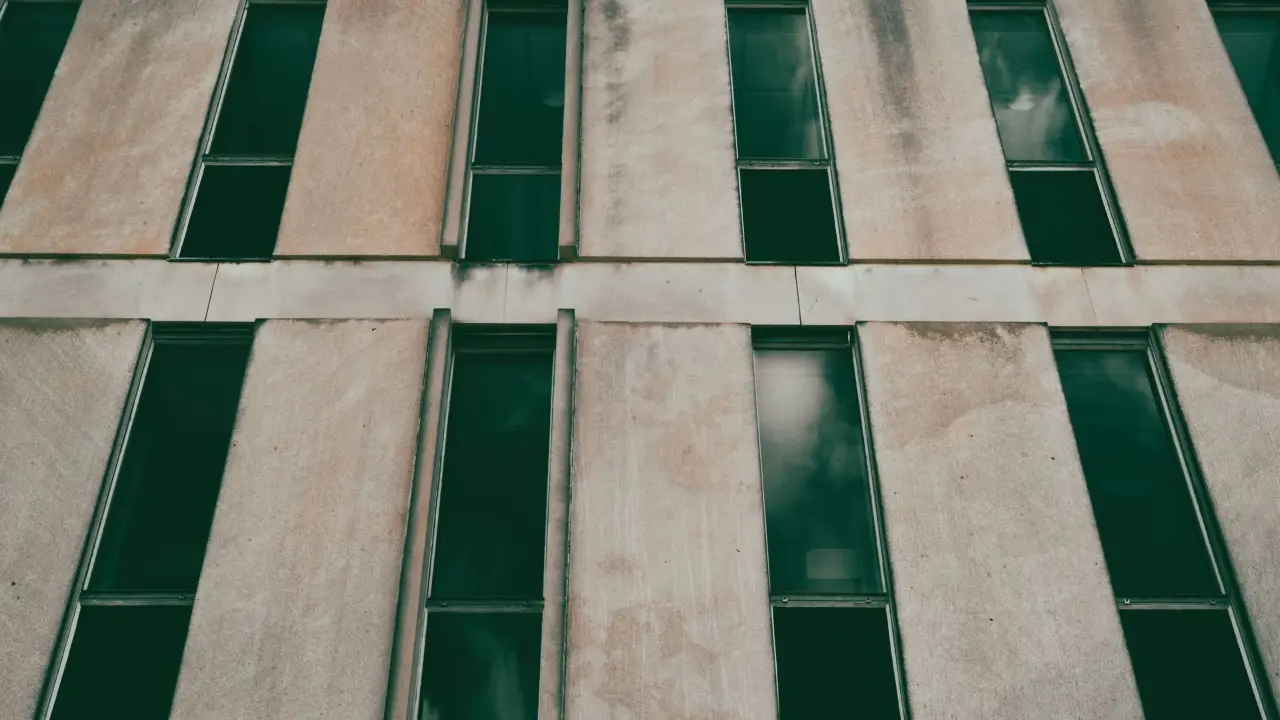 Façade de béton percée de fenêtres étroites posées en quinconce.